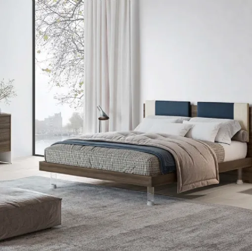 Letto matrimoniale in nobilitato finitura Forestal Dark con testiera rivestita da due cuscini imbottiti in tessuto e piedini trasparenti Ginevra GL14 di Marka Total Living