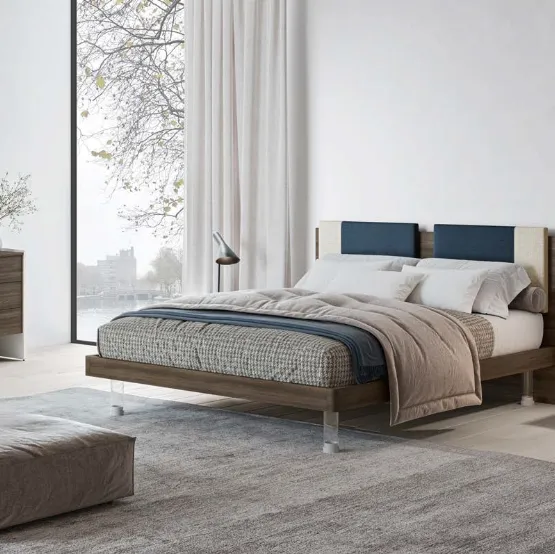 Letto matrimoniale in nobilitato finitura Forestal Dark con testiera rivestita da due cuscini imbottiti in tessuto e piedini trasparenti Ginevra GL14 di Marka Total Living